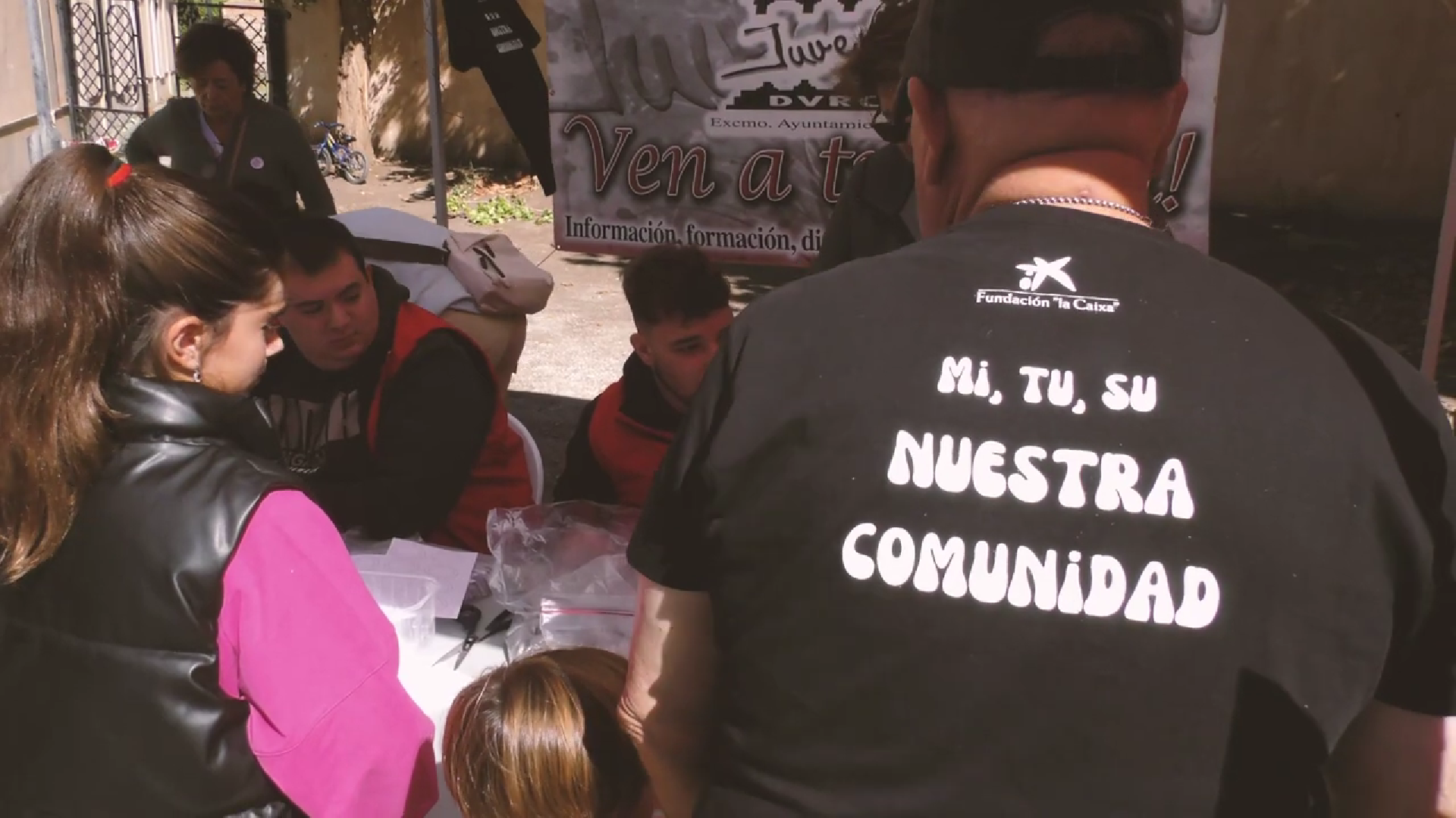 Personas de la comunidad interesados en un stand de una de las asociaciones asistentes en la Feria de Asociaciones generada desde el proyecto "MI,Tu, Su, Nuestra Comunidad"