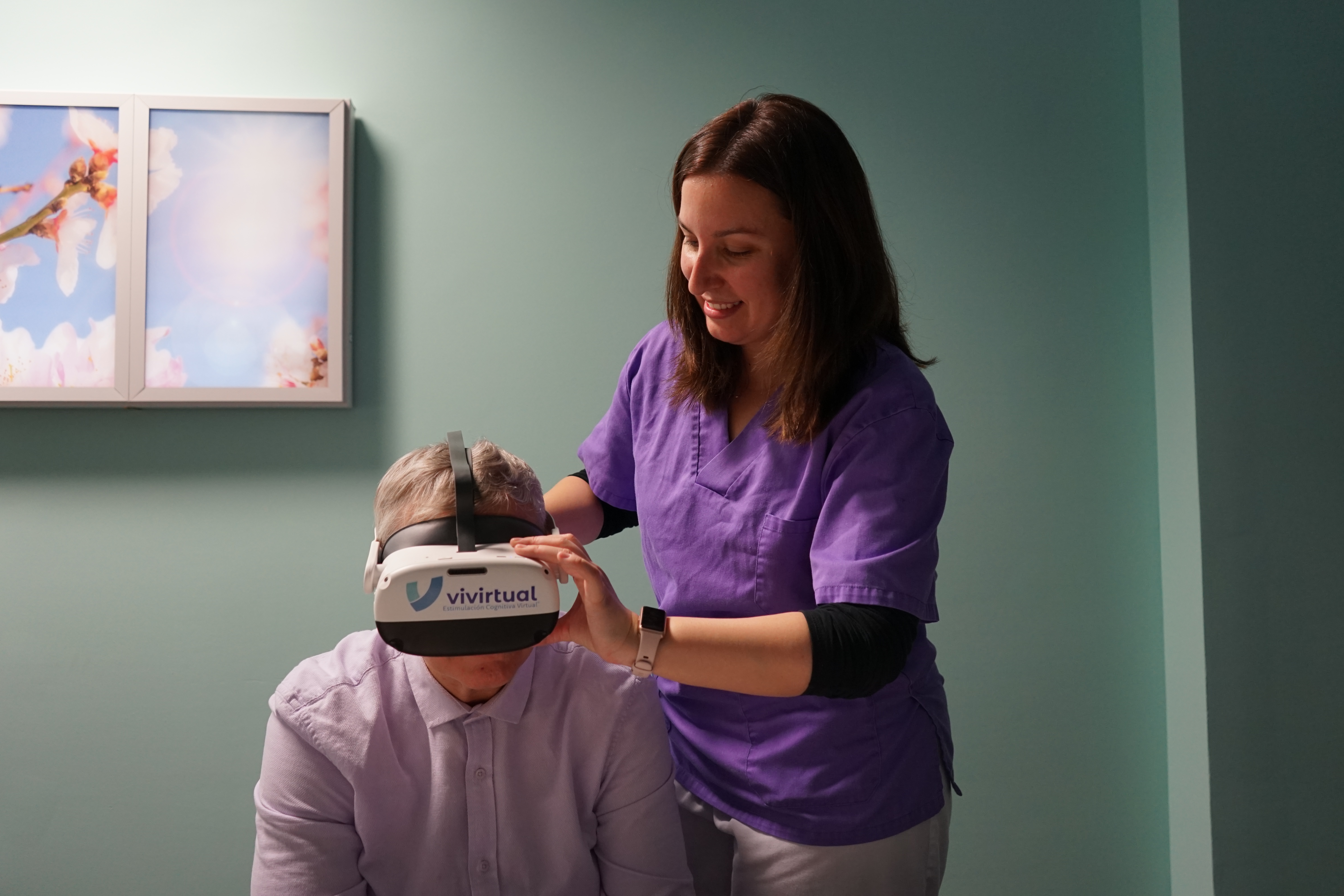 La terapeuta ocupacional de Fundación Betesda ayuda a un usuario del taller a ponerse las gafas de realidad virtual, para iniciar una sesión.