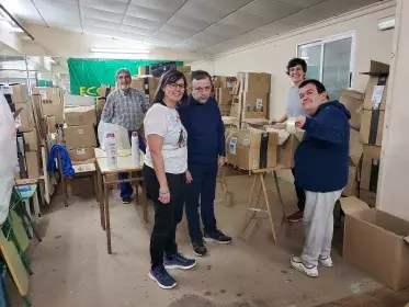 Voluntarios de la entidad Sin Fronteras junto a integrantes del grupo APS de C.O empaquetando productos de higiene y alimentos para la campaña solidaria por Grecia.