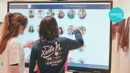 Una persona, acompañada de su apoyo, selecciona en la plataforma digital las actividades en las que desea participar