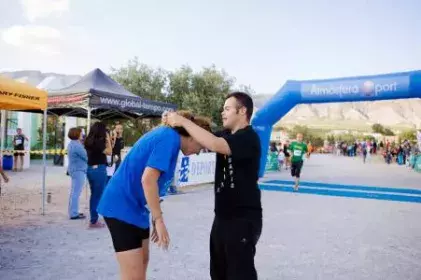 Cristian entregando medalla a una participante del Desafío Vale.